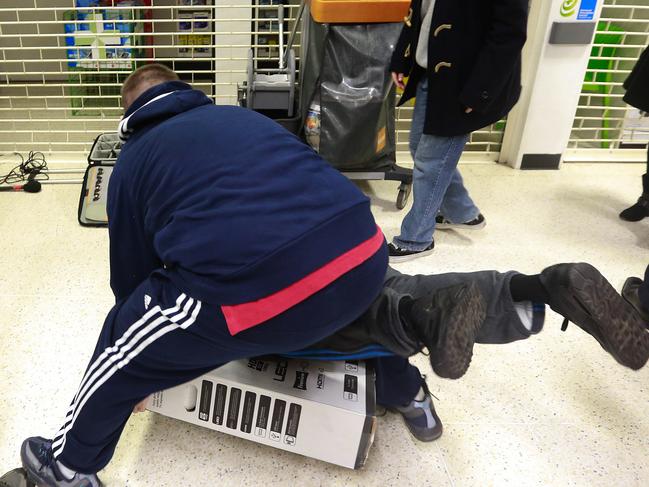 Customers fall to the floor as they grapple for an LED television during a Black Friday discount sale at an Asda supermarket, operated by Wal-Mart Stores Inc., in the Wembley district of London, U.K., on Friday, Nov. 28, 2014. Black Friday has caught on in the U.K. and worldwide over the last few years as the rise of the Internet has made the event a global phenomenon, with customers always being just one click away from the deals offered by U.S. retailers online. Photographer: Simon Dawson/Bloomberg via Getty Images