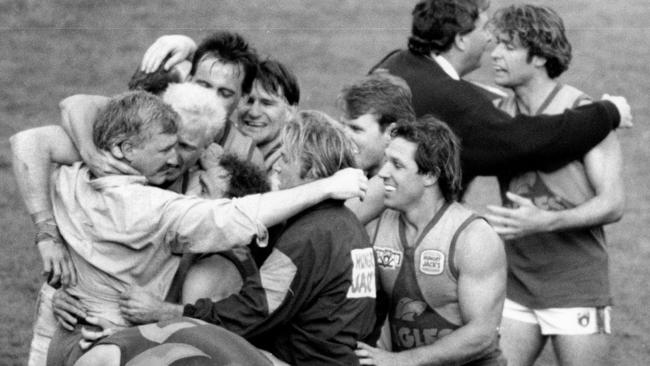 The ecstasy ... Mick Malthouse embraces his players after their 1992 Grand Final win.