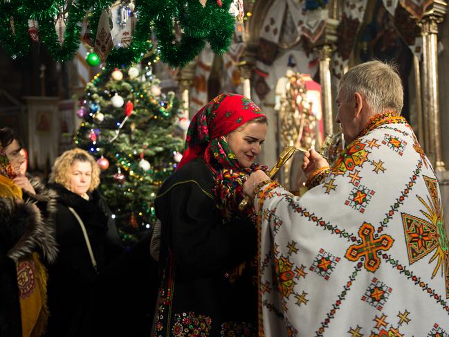 A woman receives an anointing at Holy Trinity Church on Christmas Day that is called Rizdvo in Ukrainian. Picture: Getty