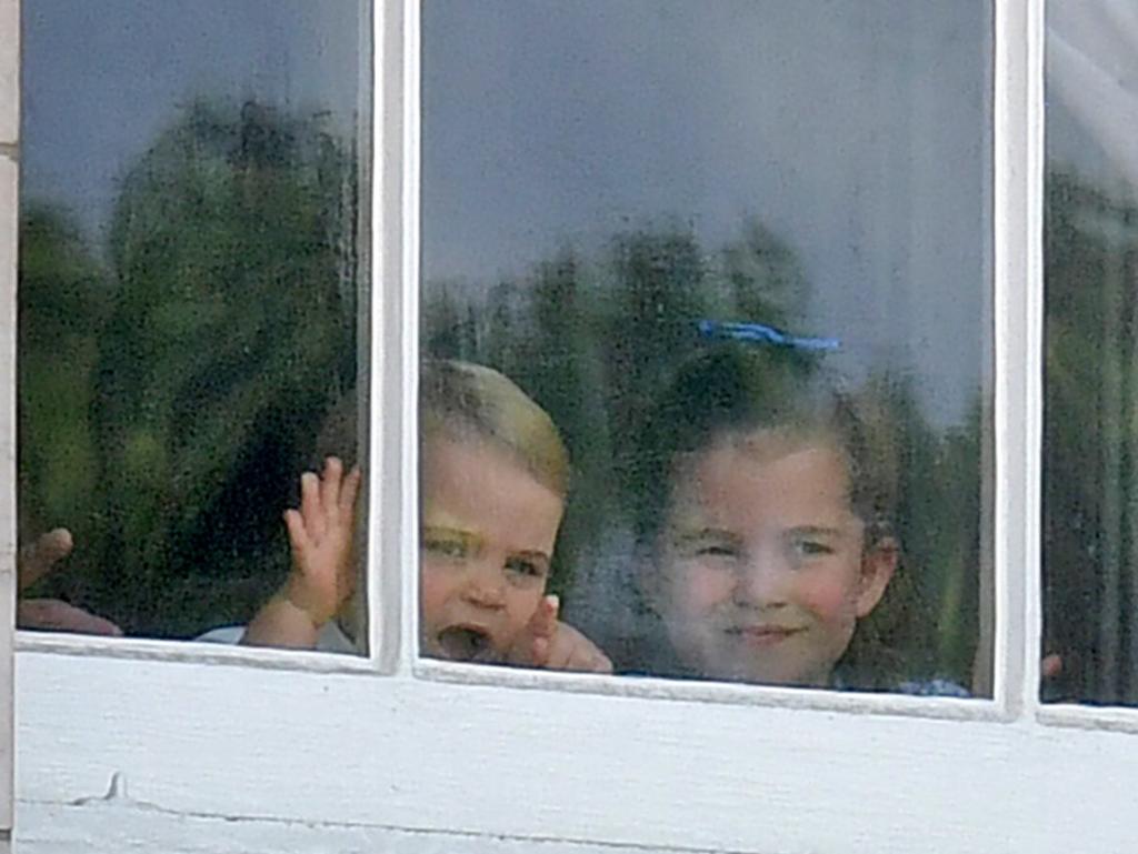 Prince Louis (L) and Princess Charlotte peer from a window in Buckingham Palace before a fly-past of aircraft by the Royal Air Force, in London on June 8, 2019. Picture: AFP