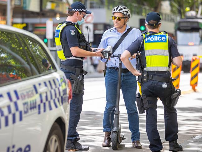 Police stop a scooter rider. Picture: Jake Nowakowski