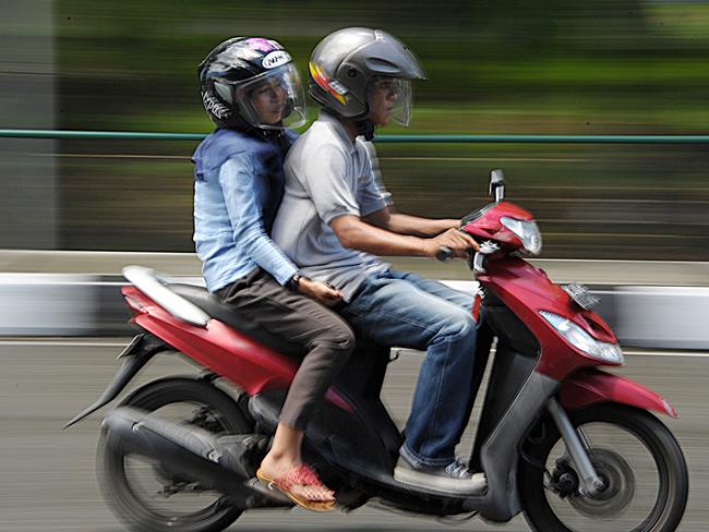 A man and a woman ride a motorbike in Banda Aceh on May 4, 2015. North Aceh district in Indonesia's Aceh has passed legislation banning unmarried men and women from riding together on motorbikes, a lawmaker said on May 4, the latest new Islamic regulation in the conservative province. AFP PHOTO / CHAIDEER MAHYUDDIN