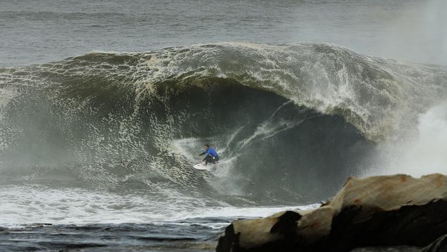 Evan Faulks rides a wave during the Red Bull Cape Fear surf competition at Cape Solander, Sydney. Picture: Brett Costello