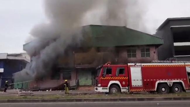 Smoke rises from a building set alight during protests in Honiara on Wednesday. Picture: AFP