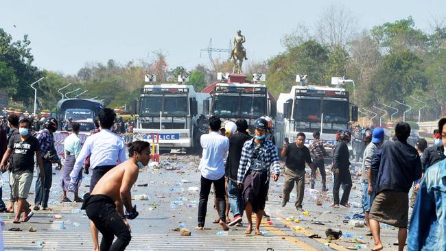 Protesters confront police vehicles after firing water cannons during a demonstration. Picture: AFP