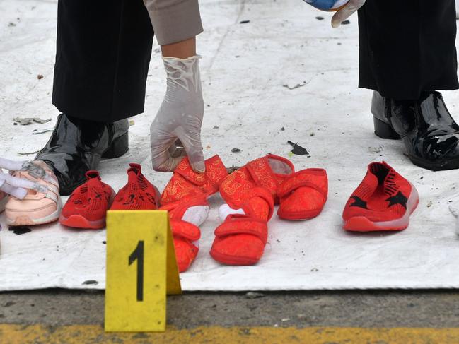 A policewoman displays shoes, recovered during search operations, from passengers onboard the ill-fated Lion Air flight JT 610 in Jakarta on October 31, 2018. - The smashed fuselage of a crashed Indonesian Lion Air jetliner may have been found, a top military commander said on October 31, as Jakarta ordered the removal of the budget carrier's technical director and staff who cleared the doomed flight for take-off. (Photo by ADEK BERRY / AFP)