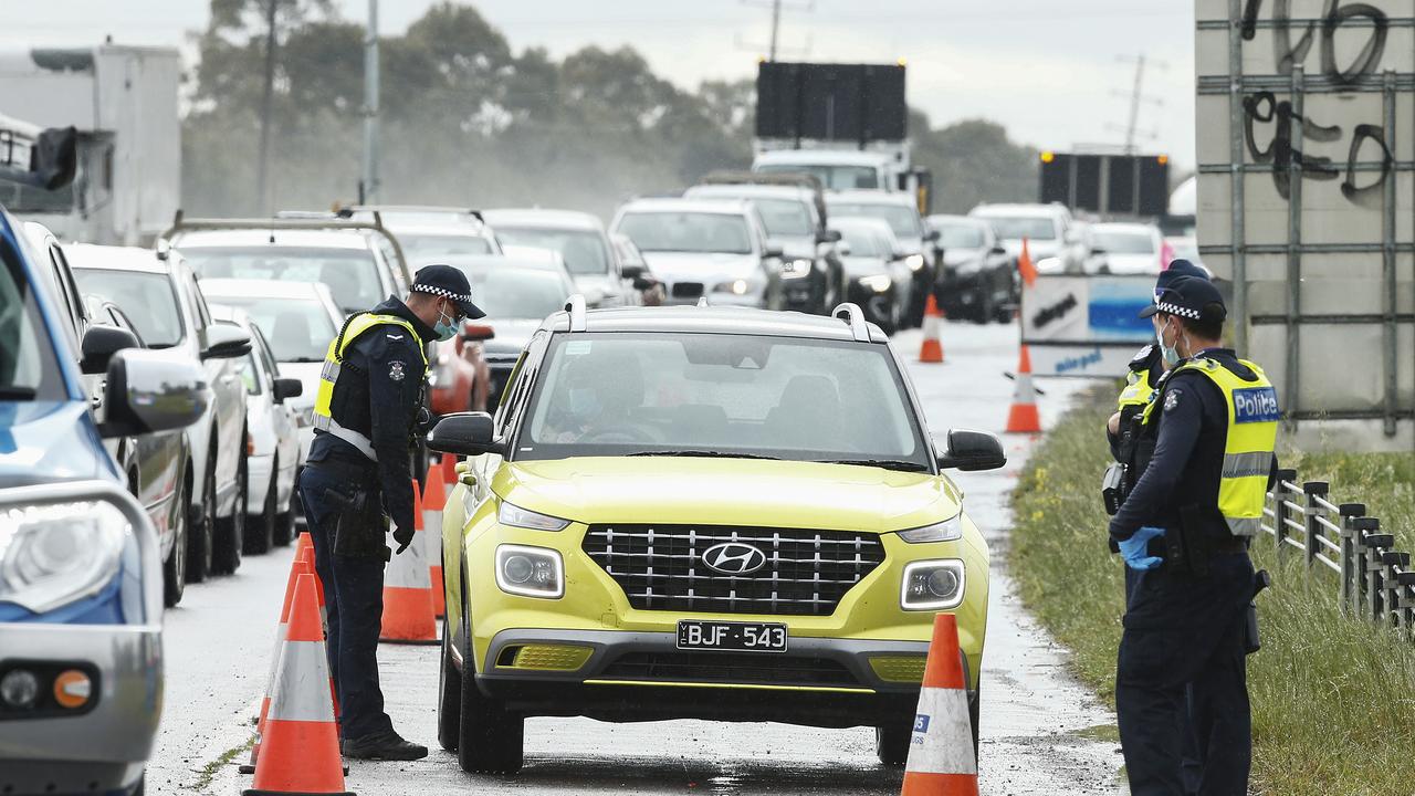 Police and ADF check work permits and identification at a roadblock in Little River near Geelong on Thursday. Picture: Daniel Pockett/Getty Images