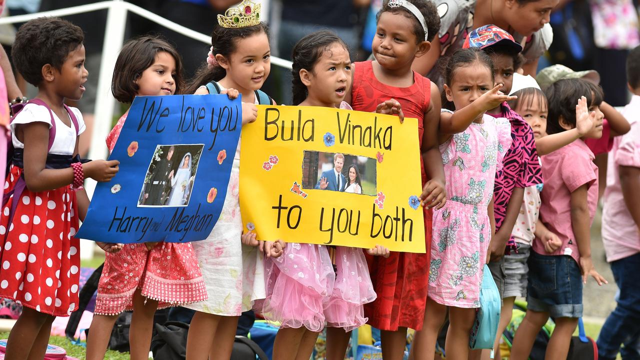 Children hold posters to welcome Harry and Meghan in Suva on Wednesday. Picture: Peter Parks.