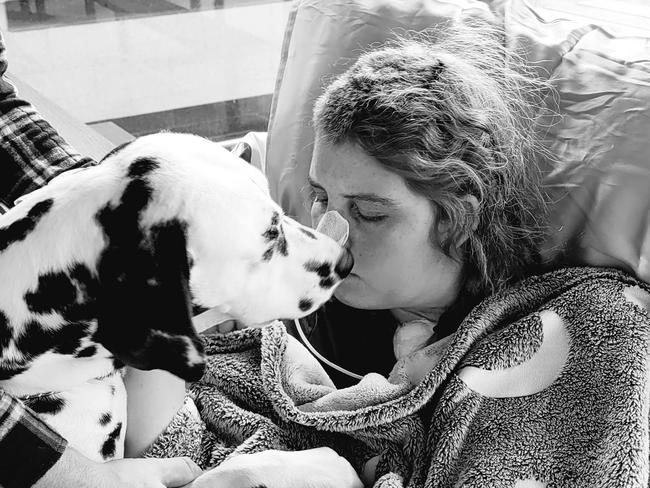 Katy Innes and her pet dog Charlotte in hospital. Katy, 25, is recovering from a brain bleed at the RHH. She is 31 weeks pregnant and has made progress, but has a huge road ahead. Source: SUPPLIED.