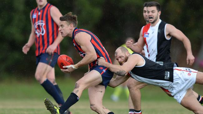 East Malvern champion Ryan Mullett gets away a handball against St Kilda City.