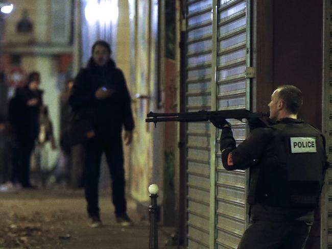 Tense situation ... A French police officer took cover while on the lookout for the shooters who attacked the restaurant 'Le Petit Cambodge' earlier in Paris. Picture: EPA/ETIENNE LAURENT