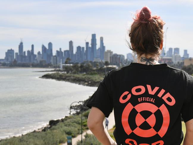 A woman looks out over the Melbourne skyline as she takes a break from exercising on August 11, 2020. - Victoria state reported 19 deaths from coronavirus on August 11, making it the country's equal deadliest day of the pandemic despite a fall in new case numbers. (Photo by William WEST / AFP)