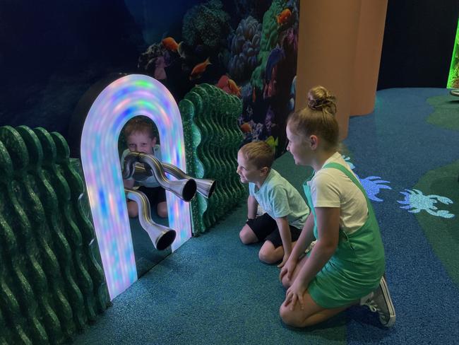 Kayla, 10, and Rory Downes, 6, try out the magic talk tubes in Reef Play, the new play space in Willows Shopping Centre. Picture: Leighton Smith.