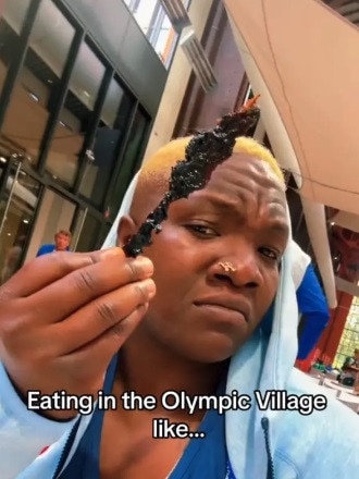 Raven 'Hullk' Saunders, an American track and field athlete holding a piece of food in the Olympic Village. (Worm not pictured) Picture: TikTok / @giveme1shot