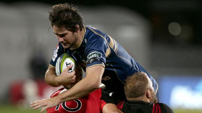 Brumbies Sam Carter, centre, attempts to bust the tackle of Crusaders Codie Taylor and Owen Franks, right, during their Super 15 rugby match in Christchurch, New Zealand, Saturday, Feb. 25, 2017. (AP Photo/Mark Baker)