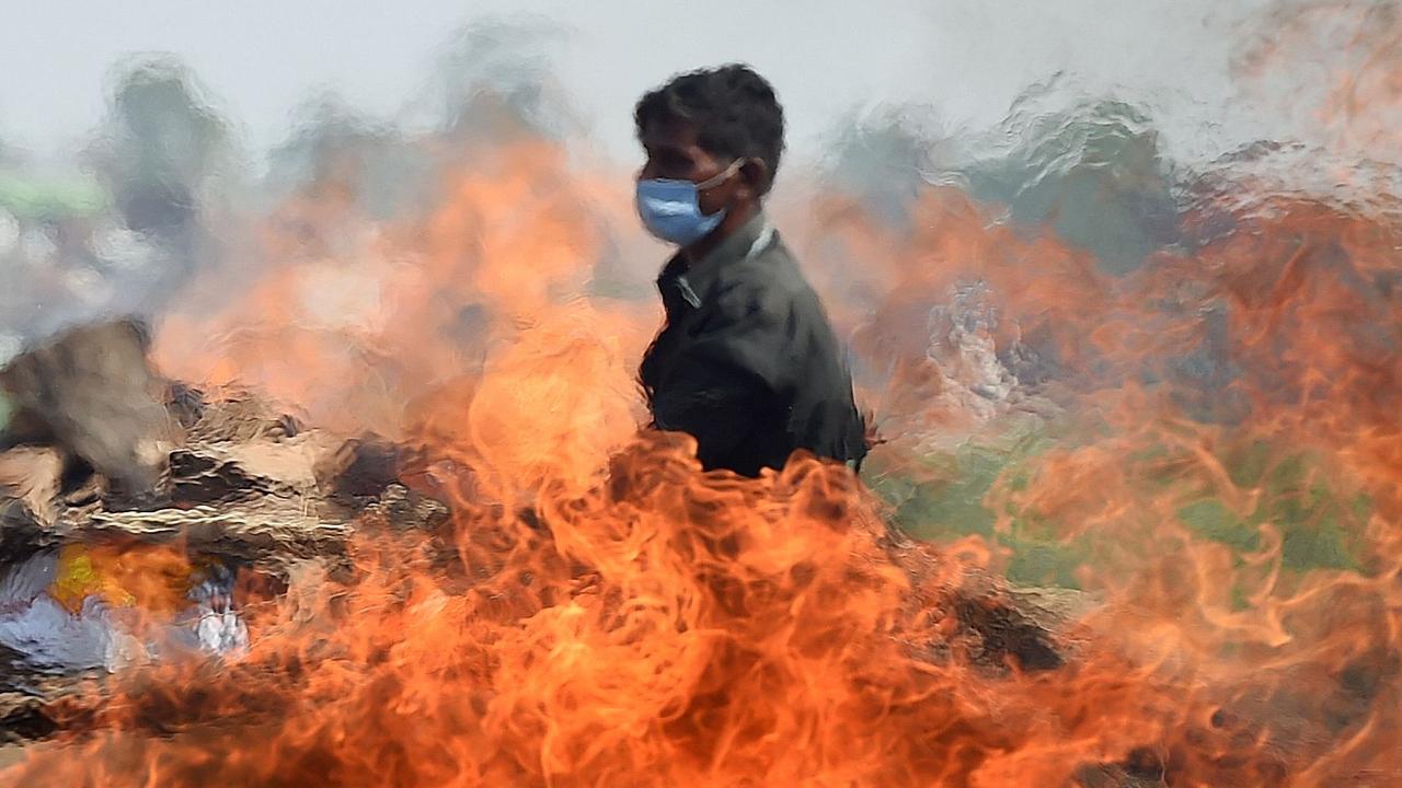 A worker walks past a burning funeral pyre of a person who died due to COVID-19 at a cremation ground in Allahabad. Picture: Sanjay Kanojia/AFP