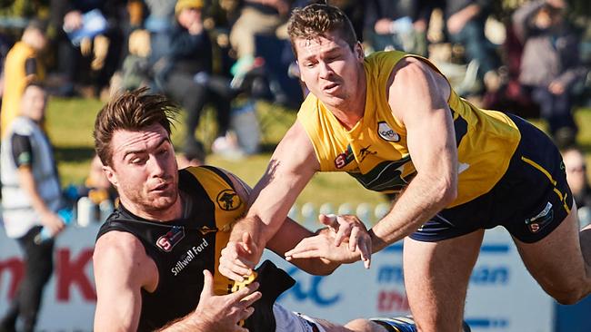 Glenelg’s Liam McBean and Woodville-West Torrens Jesse Lonergan fight for the loose ball in the gripping encounter which went down to the wire. Picture: Matt Loxton