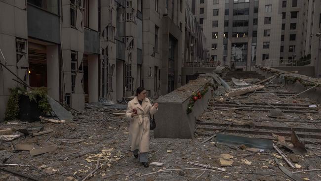 TOPSHOT - A woman walks among rubbles at the site of a missile attack in Kyiv on December 20, 2024, amid the Russian invasion of Ukraine. Russian missiles targeted the Ukrainian capital Kyiv at sunrise on December 20, 2024, killing at least one person and cutting heating to hundreds of residential buildings in cold temperatures. (Photo by Roman PILIPEY / AFP)