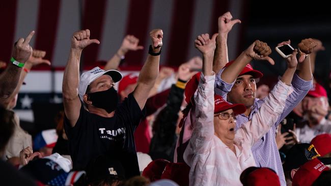 Supporters yell and gesture at media on the press riser after President Donald Trump used denigrating language about the profession at a campaign rally on October 16.