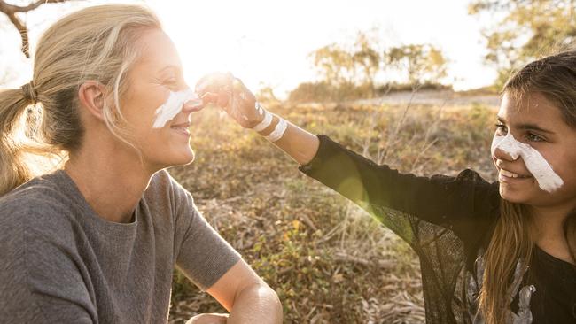 A Barkindji girl paints the face of a woman in Wilcannia, NSW.