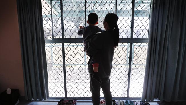 Another mother holds her son inside their cottage. Picture: Sam Ruttyn