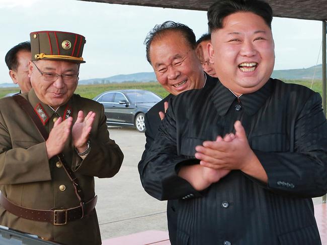 North Korean leader Kim Jong-un, centre, celebrates what was said to be the test launch of an intermediate range Hwasong-12 missile at an undisclosed location in North Korea. Picture: AP