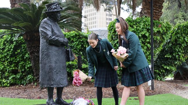 Seymour College students Charli-Rose and Matilda Costello lay a wreath at the base of the statue of the Queen in the grounds of Government House. NCA NewsWire / David Mariuz