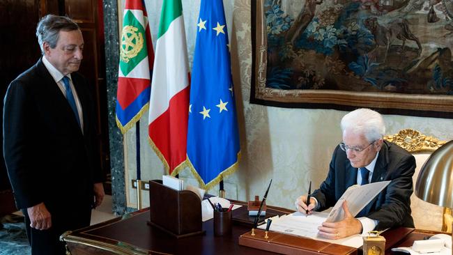 Sergio Mattarella signs the order to dissolve parliament in front of Mario Draghi on Thursday night. Picture: AFP