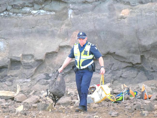 A policeman is seen retrieving people’s belongings from the rubble. Picture: Mark Wilson