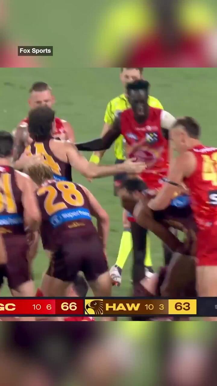 Gold Coast players run in to shove Hawthorn player