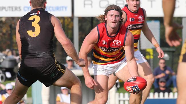 Adelaide's Sam Berry fires out a handball under pressure from Glenelg’s Matthew Snook at the Bay oval. Picture: Dean Martin