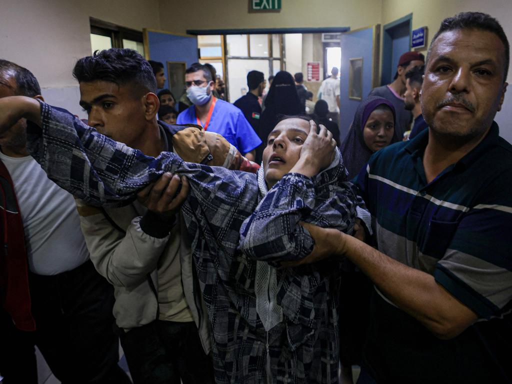 A wounded Palestinian woman from the Baraka family is helped by men to reach the emergency ward at Nasser Hostpial in Khan Yunis in the southern Gaza Strip. Picture: AFP