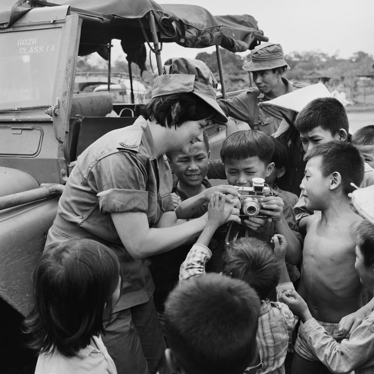 Still fond of Viernam ... Colleen Thurgar (nee Mealy) shows children from the village of Hoa Long how to operate her camera.