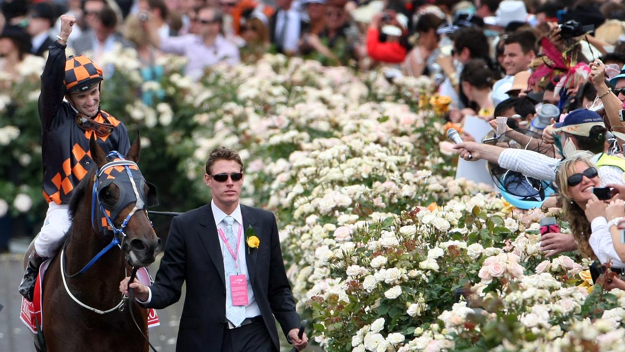 Winner Shocking with jockey Corey Brown punches the air by the roses on return to Mounting Yard.