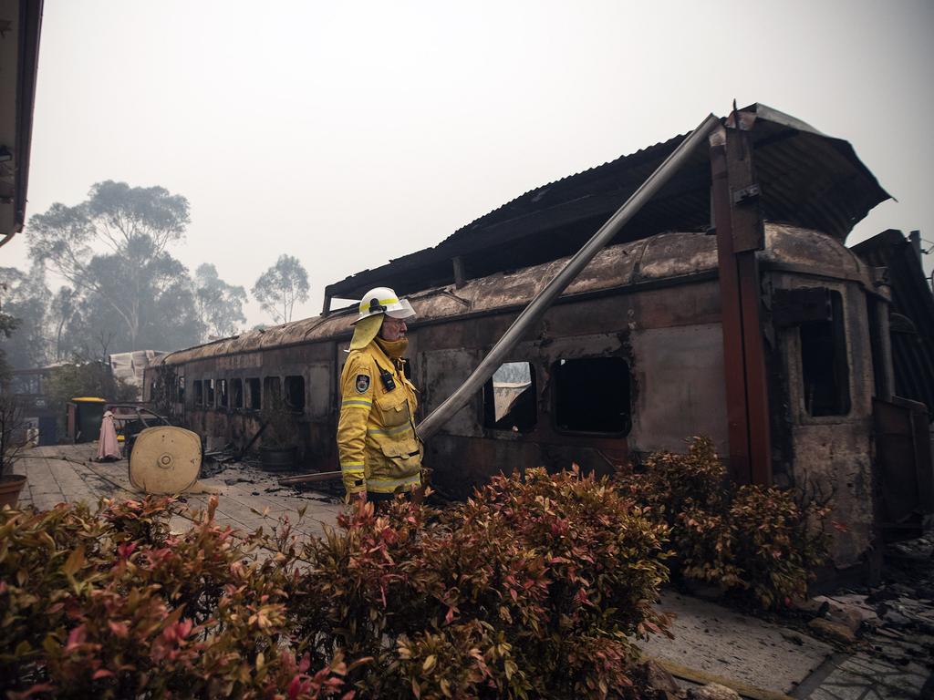 RFS volunteers assess the damage in the main street of Cobargo on New Year’s Day. Picture: Gary Ramage