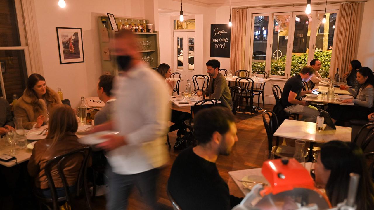 Diners eat and drink at an Italian restaurant. Picture: Steven Saphore / AFP