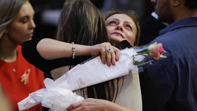 Lindt Cafe siege survivor Marcia Mikhael is embraced during a memorial service marking the first anniversary of Lindt Cafe Siege in Martin Place, Sydney, Australia, Dec. 15, 2015. Picture: Lisa Maree Williams/Pool Photo via AP