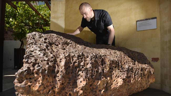Paleontologist Dr Mikael Siversson with the Mundrabilla iron meteorite, Australia's largest known meteorite.