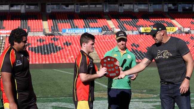 Mark Geyer and Ben James present the trophy to Loyola Senior High team captain Ayden Carling and vice captain Clinton Aiono. Picture: Pranesh Nageshwar