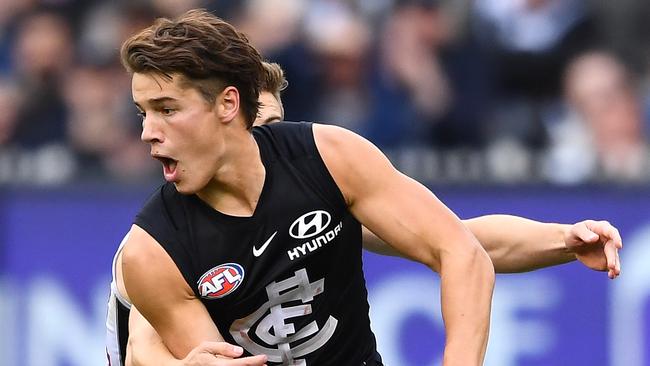 Liam Stocker handballs during his AFL debut against Collingwood.