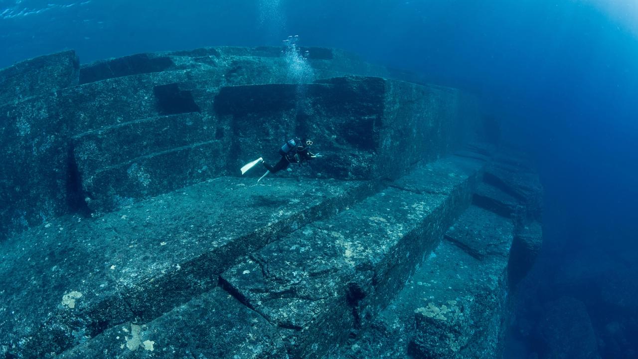 Scuba diver exploring the Yonaguni Monument, a submerged rock formation off the coast of Japan. It is unknown if these sandstone rocks are formed naturally or are of human construction, Yoguni, Japan. 2017. Picture: Alamy