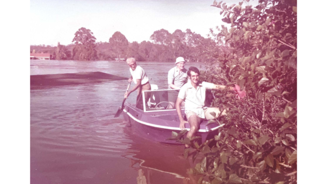 Volunteers use a boat to rescue what they can from the flooded college.