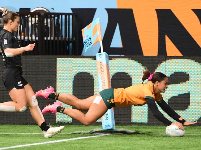 Australia's Faith Nathan scores a try chased by New Zealandâs Michaela Brake during the HSBC World Rugby Sevens Series women's rugby match between Australia and New Zealand at BC Place Stadium in Vancouver, Canada, on February 23, 2025. (Photo by Don MacKinnon / AFP)