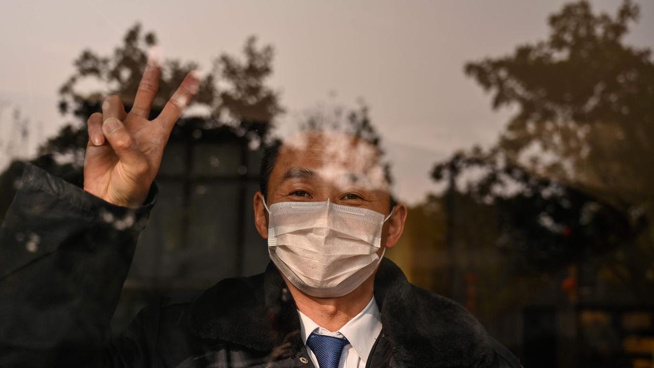 A hotel guard gestures while looking at the camera in Wuhan. Picture: AFP