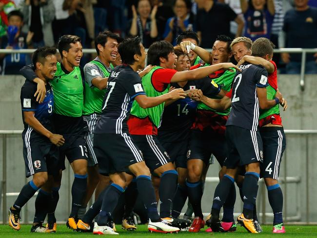 Yosuke Ideguchi (second right) of Japan celebrates scoring his side's second goal.