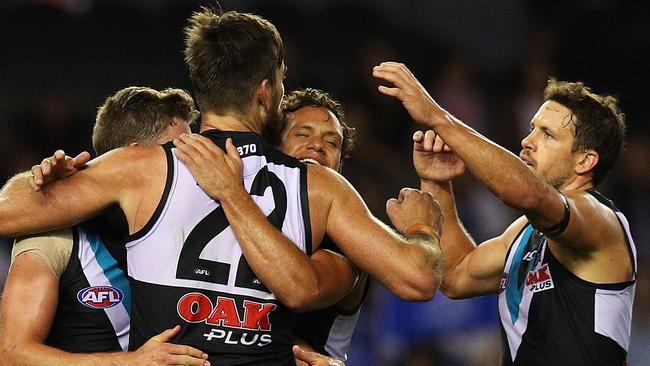 Charlie Dixon celebrates with teammates after kicking a goal.