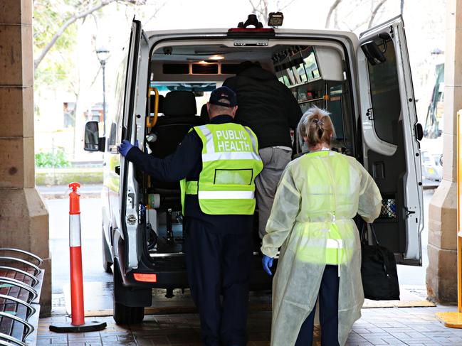 A man is taken away after arriving at Central Station with coronavirus symptoms. Picture: Adam Yip