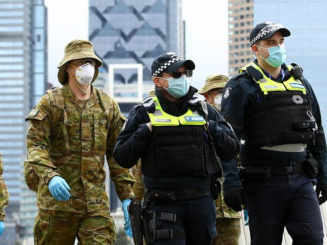 MELBOURNE, AUSTRALIA - JULY 23: Police and the Australian military patrol the banks of the Yarra River on July 23, 2020 in Melbourne, Australia. Face masks or face coverings are now mandatory for anyone leaving their homes in the Melbourne metropolitan area or the Mitchell Shire. Under the new rule, which came into effect at midnight on Thursday, anyone failing to wear a mask in public can receive a $200 fine. Metropolitan Melbourne and the Mitchell shire remain in lockdown due to the rise in COVID-19 cases through community transmissions, with residents in lockdown areas under stay at home orders until 19 August. People are only able to leave home have for exercise or work, to buy essential items including food or to access childcare and healthcare. (Photo by Robert Cianflone/Getty Images)