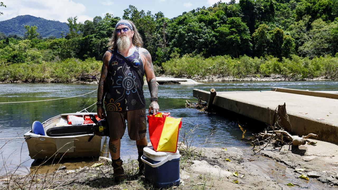 Goldsborough Valley local Nigel Young punts across the Mulgrave River on a small tinnie rigged up to a pulley system, after clearing felled trees on his property. Picture: Brendan Radke