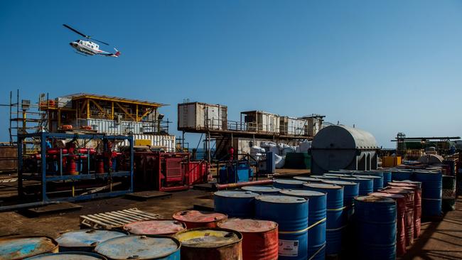 A helicopter flies over oil storage drums aboard an offshore oil platform in the Persian Gulf's Salman Oil Field, operated by the National Iranian Offshore Oil Co. Picture: Bloomberg